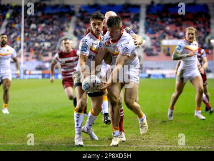 Tom Davies dei Catalans Dragons (a destra) cattura la palla per impedire ai Guerrieri Wigan di provare durante la partita della Betfred Super League al DW Stadium di Wigan. Data immagine: Giovedì 9 marzo 2023. Foto Stock