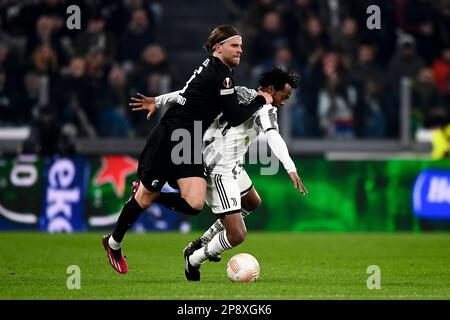 Torino, Italia. 09 marzo 2023. Juan Cuadrado della Juventus FC compete per la palla con Lucas Holer del SC Freiburg durante la partita di calcio della UEFA Europa League 16 tra Juventus FC e SC Freiburg. Credit: Nicolò campo/Alamy Live News Foto Stock