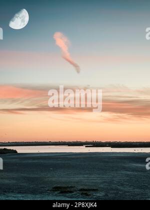 Paesaggio mozzafiato con tramonto e Luna nelle paludi saline di Carboneros, a Chiclana de la Frontera, provincia di Cadice, comunità autonoma di Andalus Foto Stock