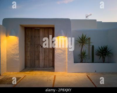 Facciata dipinta di bianco di una bella casa illuminata al tramonto Foto Stock