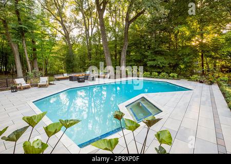 L'esterno di una casa ristrutturata con nuovi giardini, piantagioni e una piscina Foto Stock