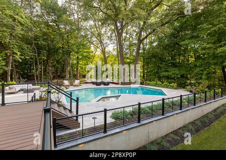 L'esterno di una casa ristrutturata con nuovi giardini, piantagioni e una piscina Foto Stock