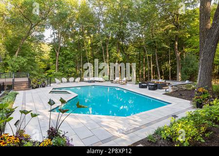 L'esterno di una casa ristrutturata con nuovi giardini, piantagioni e una piscina Foto Stock