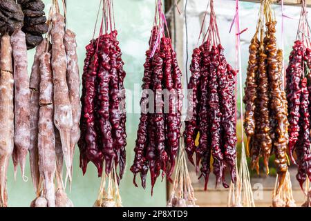 Churchkhela, tradizionale caramella georgiana a forma di candela fatta di mosto d'uva, noci e farina, appesa in una bancarella del mercato centrale di Kutaisi. Foto Stock