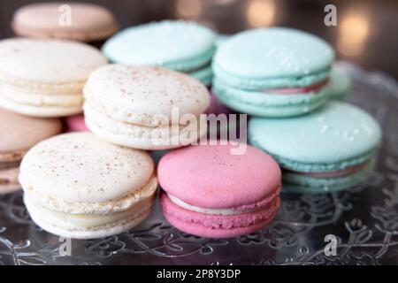 Diversi colori di macaron impilati su una lastra di vetro trasparente Foto Stock