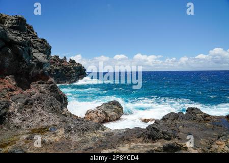 Situato sulla costa NW di Maui, Nakalele Blowhole è un geyser naturale dove l'acqua marina intrappolata in un tubo di lava subacquea è alla ricerca di una via d'uscita. Foto Stock