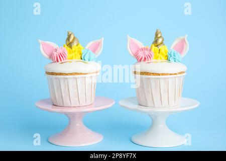 Tortini dolci e carini di unicorno su sfondo azzurro Foto Stock