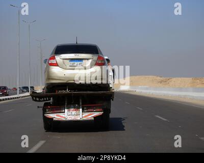 Cairo, Egitto, 8 2023 marzo: Un carro attrezzi per il recupero del rimorchio autocarro idraulico a pianale che sposta un'auto rotta che si muove per strada, fuoco selettivo di recupero Foto Stock