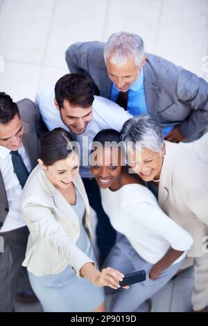 Posa della squadra. un gruppo eterogeneo di uomini d'affari che scattano una foto di squadra. Foto Stock