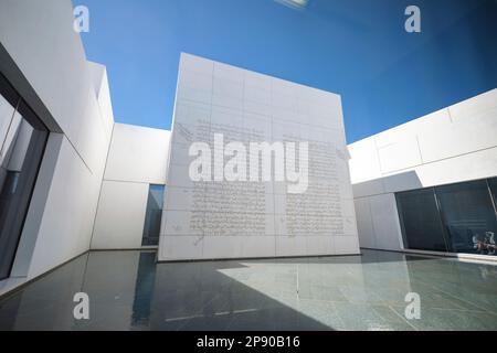 Una grande lastra di pietra bianca con riproduzione di testi antichi arabi, libro in cortile. Al museo d'arte francese del Louvre ad Abu Dhabi, Emirati Arabi Uniti Foto Stock