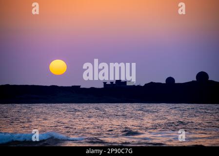 Il sole si sta gradualmente spostando verso il livello del mare. Silhouette di fabbrica al tramonto. Prestare attenzione ai cambiamenti climatici e allo sviluppo industriale. Taiwan Foto Stock