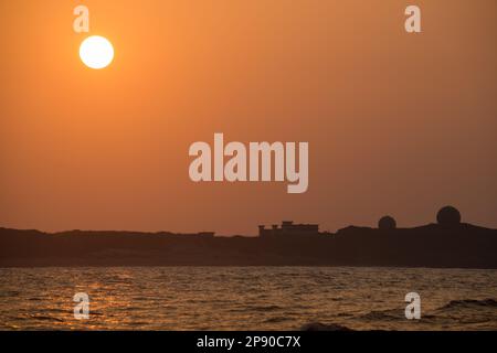 Il sole si sta gradualmente spostando verso il livello del mare. Silhouette di fabbrica al tramonto. Prestare attenzione ai cambiamenti climatici e allo sviluppo industriale. Taiwan Foto Stock