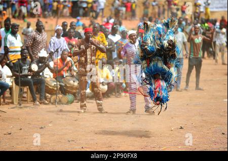 Una maschera colorata in fibra che si esibisce per la folla al Festival di stima a Dedougou, Burkina Faso Foto Stock