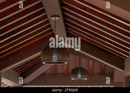 Vista ravvicinata del lampadario di rattan sul tetto della casa di legno Foto Stock