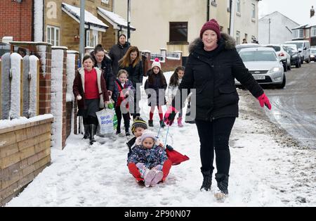 ***PERMESSO PARENTALE CONCESSO**** Una donna tira due bambini su una slitta attraverso la neve a Leeds. Data immagine: Venerdì 10 marzo 2023. Foto Stock