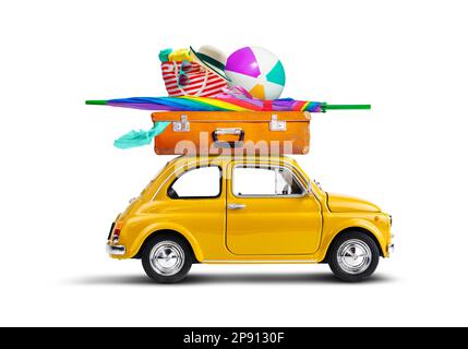 Auto giallo retro con bagagli e attrezzature da spiaggia sul tetto Foto Stock