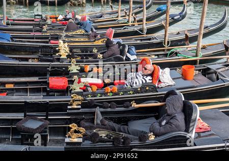 Gondolieri che riposano nelle loro gondole a San Marco, Venezia, Italia Foto Stock