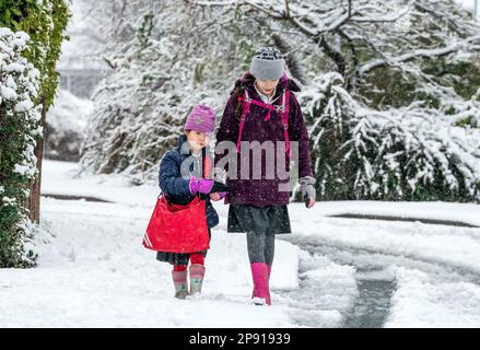 ***PERMESSO PARENTALE CONCESSO**** Bambini a piedi a scuola nella neve a Leeds. Data immagine: Venerdì 10 marzo 2023. Foto Stock