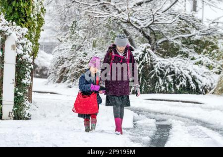 ***PERMESSO PARENTALE CONCESSO**** Bambini a piedi a scuola nella neve a Leeds. Data immagine: Venerdì 10 marzo 2023. Foto Stock