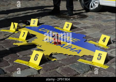 Lviv, Ucraina 10 marzo 2023. Poliziotto, automobile e ucraino mappa visto durante l'azione stradale 'Chi punirà il criminale?' In Ucraina di Leopoli. L'obiettivo: Attirare l'attenzione del mondo sul fatto che gli occupanti russi devono rispondere per nome per i crimini commessi in Ucraina. Foto Stock