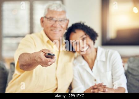 Ritratto di coppia senior guardando la tv sul divano con commedia show, film o film a casa insieme con amore e abbraccio. Persone biraciali o donne con Foto Stock