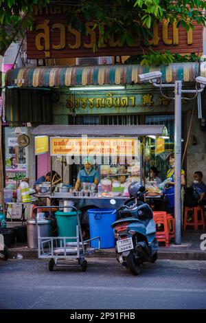 Bangkok Ratchawat Thailandia persone preparare cibo di strada tailandese in una bancarella con un wok padella soffriggere. Foto Stock