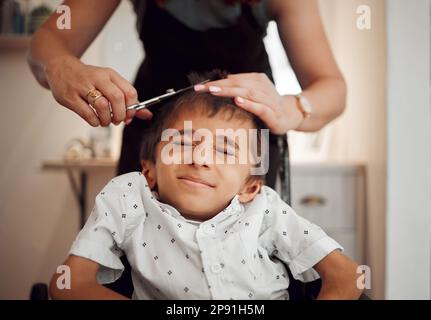 Bambino disabili, taglio capelli e mani di parrucchiere, cura dei capelli e servizio di cura dei capelli del salone per bambini disabili. Barbiere studio, paralisi cerebrale Foto Stock