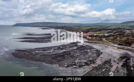 robin hood bay e le cicatrici rocciose in bassa marea vicino a whitby north yorkshire vista panoramica elevata Foto Stock