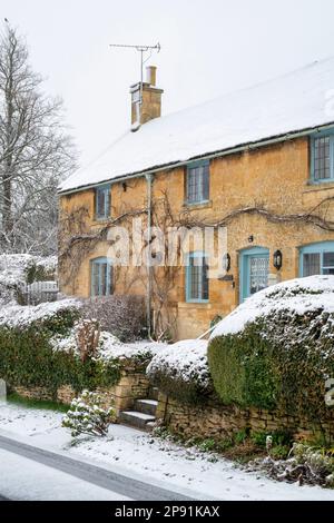 Cottage Cottswold nella neve di marzo. Bourton on the Hill, Cotswolds, Gloucestershire, Inghilterra Foto Stock