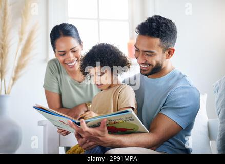 Insegnandole alcune cose nuove. Scatto di una giovane famiglia che legge un libro insieme a casa. Foto Stock