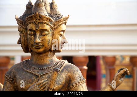 Dio indù Brahma oro shabby vecchia statua in Thailandia. Bella religione indiana tradizionale scultura del signore con per i volti in un santuario Foto Stock