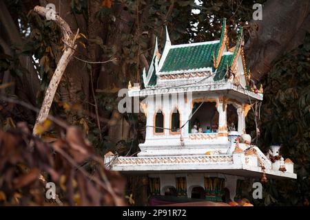 Religiose Thai spirito verde casa tra alberi per adorare e le offerte per gli dèi. Miniatura piccolo tempio buddista all'aperto in giardino Foto Stock