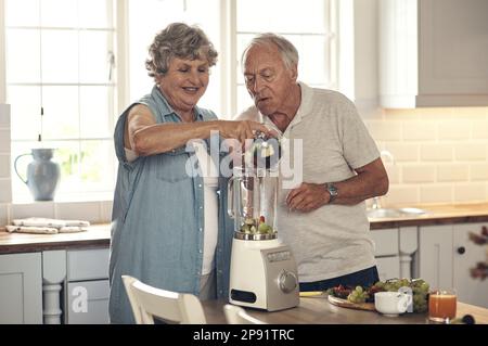 Oggi si facevano frullati. Shot di una coppia anziana che fa un frullato in cucina a casa. Foto Stock