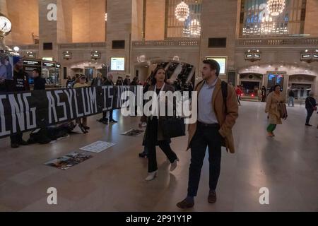 New York, New York, Stati Uniti. 9th Mar, 2023. (NUOVO) dimostrazione di Pro-immigrazione nella Grand Central Station. 09 marzo 2023, New York, New York, USA: Le persone camminano attraverso il Grand Central Terminal di Manhattan mentre i manifestanti che detengono un cartello e striscioni sono silenziosi durante una protesta a sostegno dei richiedenti asilo in mezzo al titolo 42 incertezza il 09 marzo 2023 a New York City. (Credit Image: © M10S/TheNEWS2 via ZUMA Press Wire) SOLO PER USO EDITORIALE! Non per USO commerciale! Foto Stock