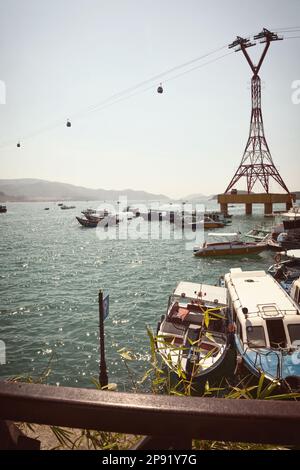 Molte navi in un asiatico porta a mare. Vari tipi di mezzi di trasporto - imbarcazioni e la funivia di Nha Trang, Vietnam Foto Stock