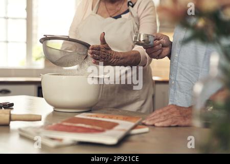 Ho sempre aiuto al mio fianco. Shot di una coppia irriconoscibile che cuoce insieme a casa. Foto Stock