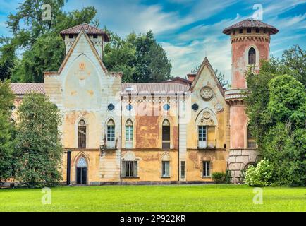 ITALIA, MIRADOLO - CIRCA AGOSTO 2020: Castello di design gotico situato in un giardino all'italiana, pieno di mistero, con luce al tramonto Foto Stock