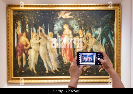 Firenze, Italia - circa 2021 luglio. Turista che fotografa Botticelli - Primavera. Caucasia donna mani con cellulare Foto Stock