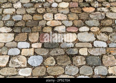 Orizzontale primo piano sfondo di colorata strada di ciottoli rotondi con molte diverse dimensioni e forma e pietre di colore Foto Stock