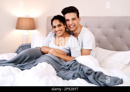 Non potevamo essere più contenti. Scatto di una giovane coppia che trascorre del tempo di qualità a letto. Foto Stock