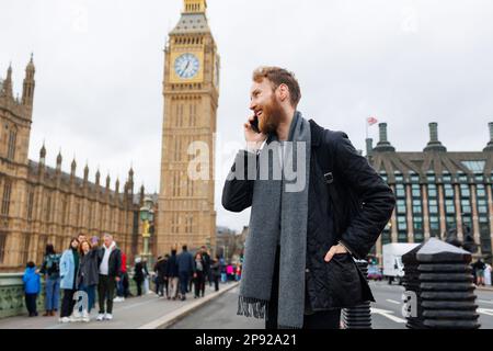 Uomo gioioso che parla al telefono nel centro di Londra Foto Stock