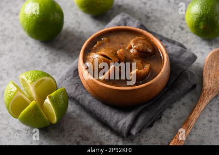 Tradizionale filone di lime dello Sri Lanka, sale, peperoncino, pepe su fondo marrone. Primo piano. Foto Stock