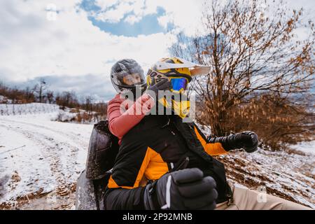 Coppia godendosi mentre guida la quad sulla cima della montagna durante l'inverno Foto Stock