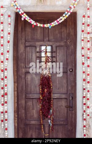 Una porta d'ingresso in legno con elementi decorativi, tra cui dettagli ornamentali Foto Stock