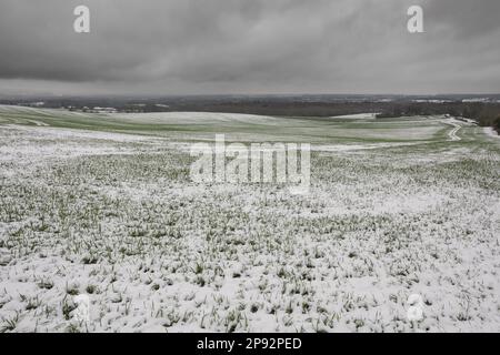 Vista mozzafiato delle nuvole buie di tempesta su colture di cereali appena piantate ai piedi di North Downs guardando verso ovest e sud verso le città di Medway e Staplehurst Foto Stock