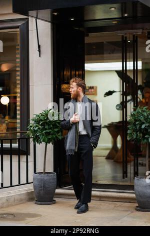Ritratto di un uomo bearded elegantemente vestito sulla strada Foto Stock
