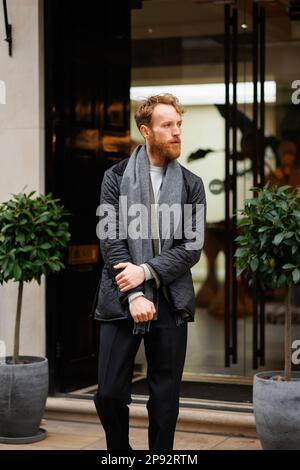 Ritratto di un uomo bearded elegantemente vestito sulla strada Foto Stock