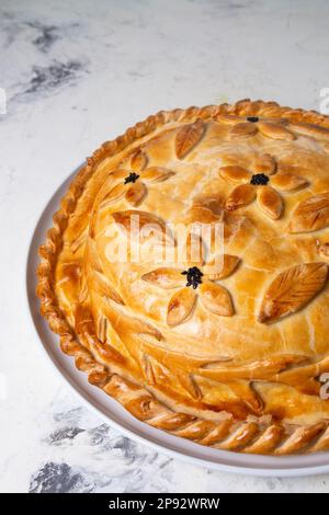 torta di pollo intera calda sul tavolo a casa. Foto Stock