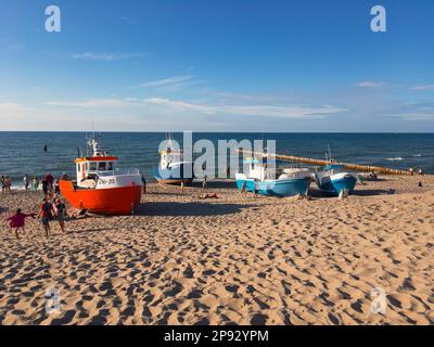 UNIESCIE, POLONIA - 6 AGOSTO 2022: Piccole barche da pesca sulla spiaggia di Uniescie, Polonia al tramonto Foto Stock