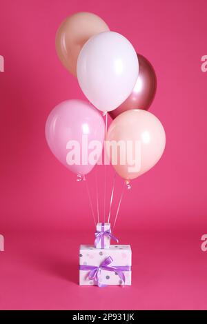 Scatole regalo e palloncini vicino a ​background rosa brillante Foto Stock